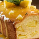 "A freshly baked Pineapple Paradise Loaf Cake with golden edges, topped with a dusting of powdered sugar and garnished with pineapple slices."