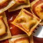 Crispy air fryer ravioli bites served with marinara sauce, ready for dipping.