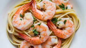 "A plate of creamy Tuscan shrimp linguine with fresh spinach and sun-dried tomatoes, garnished with Parmesan cheese and herbs."
