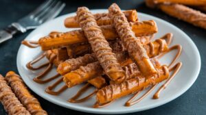 Freshly baked cinnamon sugar pretzel sticks on a parchment-lined baking sheet.