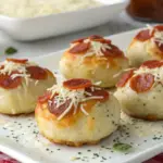 "Cheesy Pepperoni Pizza Bombs with golden crust, gooey mozzarella cheese, and marinara sauce, served on a rustic platter."