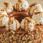 "Freshly baked Cinnabon Cinnamon Roll Cake with rich cinnamon swirls and a creamy glaze, served on a white plate."