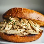 Crock Pot Ranch Chicken Sandwiches with creamy ranch sauce and shredded cheddar cheese on soft buns