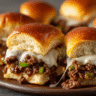 Ultra-realistic Philly cheesesteak sliders with ground beef, melted cheese, and green peppers inside golden brown buns on a seamless neutral background