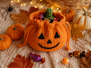Finished crochet pumpkin treat pouch filled with Halloween candy